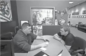  ??  ?? Devon Meyer, right, 21, meets with recruiter Staff Sgt. Cody Prisk to get his assigned workouts for the day at Marine Corps Recruiting Wausau.