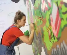  ??  ?? Dr. Magdalena Sabat, reseach and creative adviser, works on the mural, which is dedicated to the pioneers who fled slavery in the 1830s.