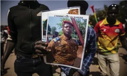  ?? Photograph: Sophie Garcia/AP ?? A man holds a portrait of Lt Col Paul-Henri Sandaogo Damiba, who led a coup overthrowi­ng the president of Burkina Faso earlier this year.