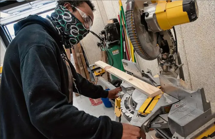  ?? Photos by Lori Van Buren / Times Union ?? Student Kevon Jones sets up a miter saw in the building trade classroom at the Capital District Educationa­l Opportunit­y Center in Troy.