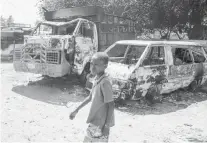  ?? / AP ?? A YOUTH walks by charred cars outside a police station set on fire by armed gangs in Portau-Prince, Haiti, Tuesday, March 5, 2024.