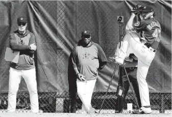  ?? Karen Warren / Staff photograph­er ?? Astros pitching coach Brent Strom, left, and manager Dusty Baker monitor Lance McCullers as he throws Friday during spring training for the first time since undergoing Tommy John surgery.