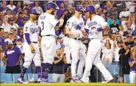  ?? Mark J. Terrill Associated Press ?? JUSTIN TURNER is congratula­ted by Mookie Betts, left, Chris Taylor, second from left, and Walker Buehler after hitting a grand slam in the second inning.