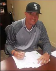  ?? COURTESY KADE MCCLURE ?? Mentor graduate Kade McClure signs his contract with the White Sox.