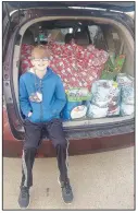  ?? (Courtesy photo) ?? Jaxton Jowers of Farmington sits in front of Christmas presents he delivered to the residents at Peachtree Village in Farmington. He raised money for the gifts by making “mask keepers,” a strap made of parachute cord with clips tied to each end. People can then attach their facemasks to each clip so the mask will hang around the neck when it’s not being worn.