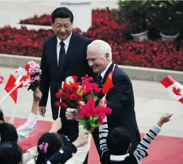  ?? KOTA ENDO/AFP/GETTY IMAGES ?? Governor General David Johnston, right, and Chinese President Xi Jinping are greeted by children outside the Great Hall of the People in Beijing on Friday. Johnston is in China to boost relations between the two countries.