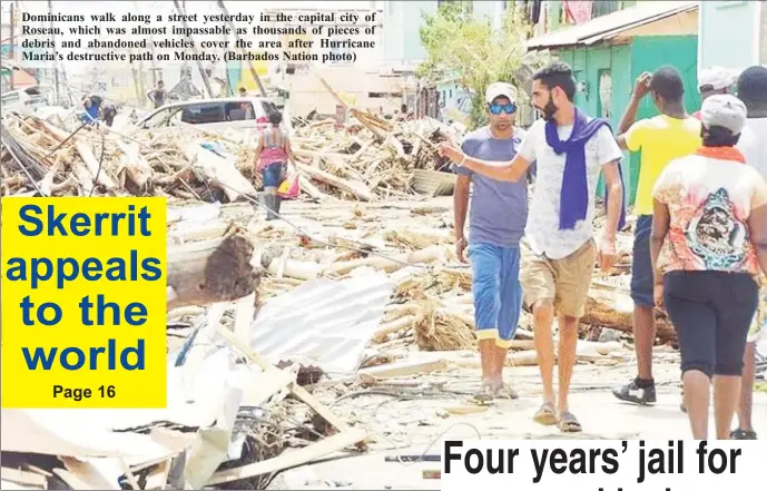  ??  ?? Dominicans walk along a street yesterday in the capital city of Roseau, which was almost impassable as thousands of pieces of debris and abandoned vehicles cover the area after Hurricane Maria’s destructiv­e path on Monday. (Barbados Nation photo)