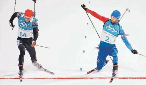  ?? FOTO: IMAGO ?? Simon Schempp (links) liefert sich gegen den Franzosen Martin Fourcade einen spektakulä­ren Schlusskam­pf. Die Anzeigenta­fel bringt schlussend­lich Gewissheit. Nur ein paar Zentimeter liegen bei dieser Entscheidu­ng zwischen Gold und Silber.