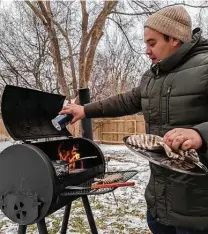  ?? Timothy Chagolla Retzloff ?? Francisco Chagolla Retzloff cooks on an outdoor grill he used to prepare almost every meal he and his husband, Timothy Chagolla Retzloff, ate for three days while the power was off in their Northwest side home. Timothy said he’ll never be caught short on firewood and charcoal again.