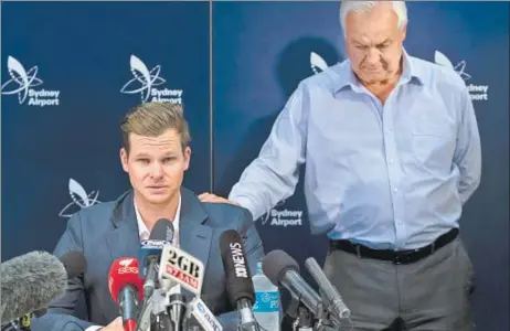  ?? GETTY ?? An emotional Steve Smith is comforted by his father Peter as he fronts the media at Sydney airport on Thursday soon after returning from South Africa.