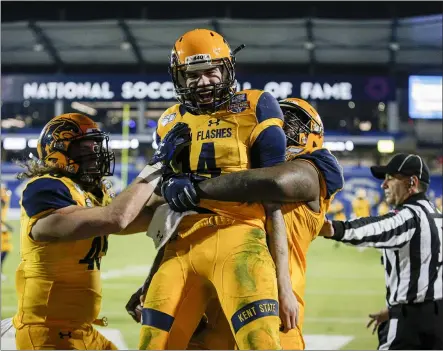  ?? BRANDON WADE — THE ASSOCIATED PRESS ?? Kent State quarterbac­k Dustin Crum is congratula­ted by teammates after scoring a touchdown during the second half against Utah State in the Frisco Bowl on Dec. 20, 2019.