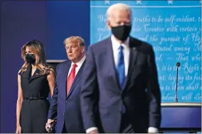  ?? [JULIO CORTEZ/ASSOCIATED PRESS FILE PHOTO] ?? First lady Melania Trump and President Donald Trump remain on stage as Democratic presidenti­al candidate former Vice President Joe Biden walks away at the conclusion of the second and final presidenti­al debate Oct. 22 at Belmont University in Nashville, Tenn.