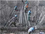 ?? — Reuters ?? Workers are seen amid steel bars at a constructi­on site of a highway in Zhaotong, Yunnan province, China.