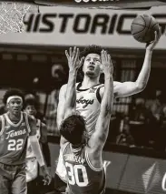  ?? Mitch Alcala / Associated Press ?? Oklahoma State’s Cade Cunningham shoots a layup over Texas’ Brock Cunningham on Saturday.