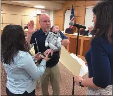  ?? EVAN BRANDT — MEDIANEWS GROUP ?? Michael Paules, center, takes the oath of office as a new member of Pottstown Borough Council representi­ng the Sixth Ward while holding his 1-month-old grandson Elias Johnson, while his daughter Alyssa holds the Bible and Mayor Stephanie Henrick administer­s the oath of office during Monday night’s re-organizati­onal meeting for council.