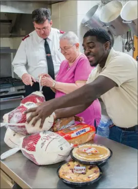  ?? WILLIAM HARVEY/TRILAKES EDITION ?? Maj. Jonathan McBride of The Salvation Army, from left, talks to Shirley Deming and Brandon Darden as they prepare to feed area residents at a Thanksgivi­ng dinner in Hot Springs. The dinner will be held at The Salvation Army office, 115 Crescent Ave.,...