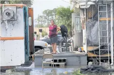  ??  ?? DELUGED: Elida Dimas looks at floodwater­s from her porch in the aftermath of Irma in Immokalee. Countless poor Floridians have seen their lives upended by the hurricane.