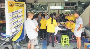  ??  ?? Volunteers at the Sarawak United People’s party (SUPP) Pending’s BR1M service counter at Kenyalang Park in Kuching assist locals who come to process their applicatio­n for the cash aid. The branch helped verify and process 250 applicatio­ns yesterday....