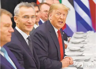 ?? NICHOLAS KAMM/GETTY-AFP ?? Secretary-General Jens Stoltenber­g, left, looks on as President Trump speaks during a working lunch at NATO’s summit.