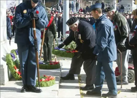  ?? PHOTOS BY MATHEW MCCARTHY, RECORD STAFF ?? An air cadet assists as wreaths are placed at the base of the Kitchener cenotaph during the Remembranc­e Day service on Saturday morning.