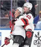 ?? FRANK FRANKLIN II/AP ?? Luke Hughes, right, hugs brother Jack Hughes during the New Jersey Devils’ game against the Islanders on Oct. 20.