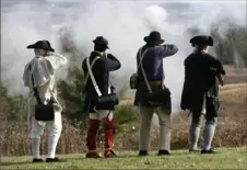  ?? Mike Groll/Associated Press ?? Revolution­ary War re-enactors fire shots before a ceremony in November 2013 at Saratoga National Historical Park in Stillwater, N.Y.