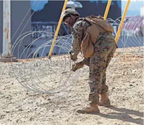  ?? JOHN GIBBINS / THE SAN DIEGO UNION-TRIBUNE/AP ?? Marine Corps engineers from Camp Pendleton put up razor wire this week just east of the San Ysidro Port of Entry where trains pass from the US to Mexico and Mexico to the US. The Trump administra­tion has said it plans to limit the ability of immigrants to seek asylum.