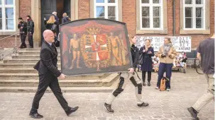  ?? (Ritzau Scanpix/Ida Marie Odgaard via Reuters) ?? A HISTORIC PAINTING of the Old Stock Exchange, Boersen, is carried away from the burning building in Copenhagen on Tuesday.