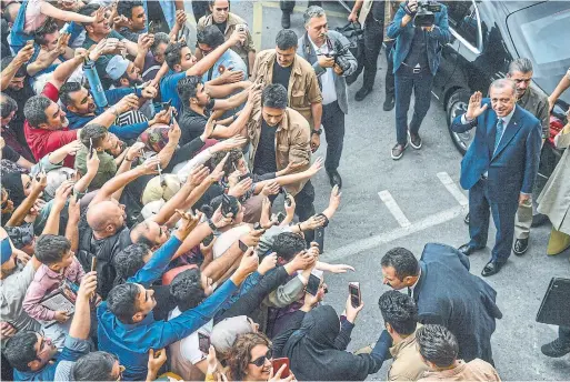  ?? BULENT KILIC/AFP/GETTY IMAGES ?? Turkey’s President Recep Tayyip Erdogan, leader of the Justice and Developmen­t Party, is greeted by supporters as he and his wife leave a polling station.