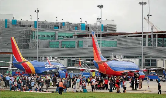  ?? REUTERS ?? Passengers and staff who fled the terminal at the Fort Lauderdale airport as a gunman killed five people wait on the tarmac for police to give the all-clear.