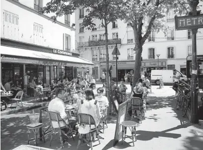  ?? CHRISTOPHE ENA AP ?? Parisians who have been cooped up for months once again dine in the fresh air of the City of Light’s cafes on Tuesday.