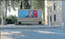  ?? Bulent Kilic / Getty Images ?? A picture of Azerbaijan's late president Heydar Aliyev is displayed in
Terter city center on Wednesday. Azerbaijan said on Wednesday it had destroyed missile launchers inside Armenia that were targeting its cities, as fierce fighting over Nagorno-karabakh risked widening beyond the disputed region.