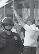  ?? PATRICK BREEN/THE REPUBLIC ?? Police stand guard as supporters of President Donald Trump enter a rally last week at the convention center in downtown Phoenix.