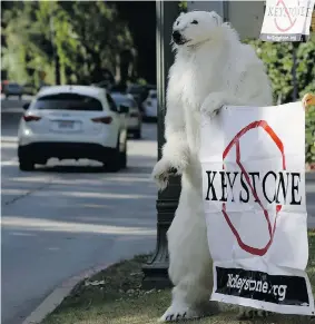  ?? DAMIAN DOVARGANES/The Associated Press ?? A member of the Center for Biological Diversity dressed as a polar bear protests the Keystone XL pipeline during a visit by President Barack Obama to Los Angeles Wednesday.