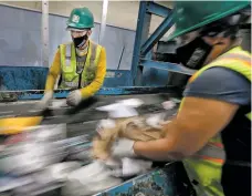  ?? JIM WEBER/NEW MEXICAN FILE PHOTO ?? Sorters Jose Perez, left, and Faviola Ponce pull out most of the remaining aluminum and plastic from a flow of recyclable materials in June 2021 at Buckman Road Recycling and Transfer Station in Santa Fe.