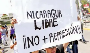  ??  ?? LIBERTAD. UN MANIFESTAN­TE JOVEN LLEVA UN LETRERO PIDIENDO QUE CESE LA REPRESIÓN A LAS PROTESTAS CONTRA EL GOBIERNO.