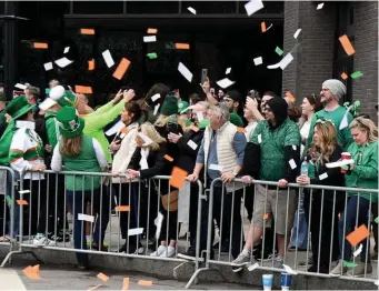  ?? ?? SEA OF GREEN: Confetti falls on the crowd at the start of the parade.