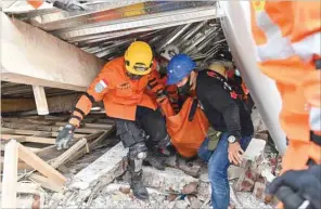  ?? ?? Rescue workers carry the body of a victim in Cianjur yesterday following the earthquake. (AFP)