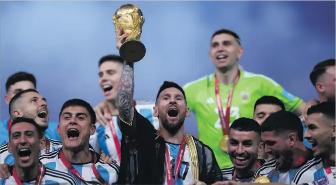  ?? Picture: REUTERS ?? Argentina’s Lionel Messi celebrates with the trophy and teammates after winning the World Cup.