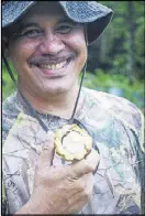  ??  ?? Ted Leiato of American Samoa Power Authority savors a bite of fresh cacao (cocoa) fruit while checking out a solar project site near Faleasao Village on the island of Tau.
