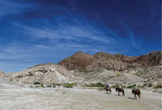  ?? Staff file photo ?? Big skies and horses are part of the myth of Texas. Horseback riders pass through Rough Run Creek outside Big Bend National Park in 2017.
