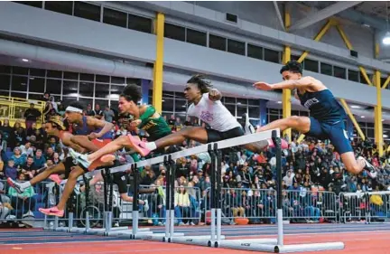  ?? TERRANCE WILLIAMS/PHOTOS FOR BALTIMORE SUN MEDIA ?? Athletes run in the boys 55-meter hurdles at the Class 4A indoor track and field state championsh­ips at the Prince George’s Sports & Learning Complex in Landover on Wednesday.