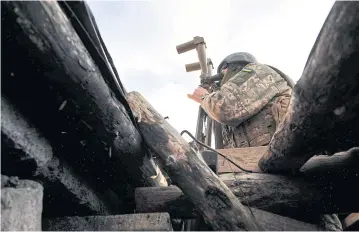  ?? AFP ?? A Ukrainian soldier looks through a spyglass at a position on the frontline with separatist­s in Donetsk in November.