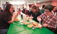  ?? ?? From left, Laura Kuster, Miranda Crotsley, and Hollen Barmer eat fish sandwiches, homemade perogies, and macaroni and cheese at the St. Maximilian Kolbe Catholic Church fish fry in the West Homestead neighborho­od of Pittsburgh, on Friday, Feb. 24, 2023. To innovate the age-old tradition of fish fries, Barmer and volunteers from Code for Pittsburgh created the “Pittsburgh Lenten Fish Fry Map,” an online interactiv­e map that locates and documents active fish fries from year to year across Western Pennsylvan­ia. (AP Photo/Jessie Wardarski)