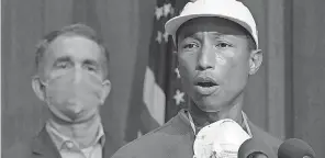  ?? BOB BROWN/ AP ?? Pharrell Williams speaks about plans to make Juneteenth a Virginia state holiday as Gov. Ralph Northam, left, listens on June 16, 2020.