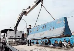  ?? HADI MIZBAN/AP ?? Iraqi security forces remove a concrete barrier Tuesday in Baghdad, the capital.