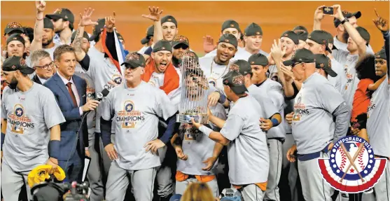  ??  ?? Los Astros de Houston celebran con el trofeo