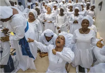  ?? BEN CURTIS/AP ?? Prayers for the nation: Members of the congregati­on at the Celestial Church of Christ Olowu Cathedral sing and chant during a Friday service on Lagos Island in Nigeria in which they prayed for the country and against the forces of evil ahead of national elections. Voters go to the polls Saturday to select a new president to succeed President Muhammadu Buhari.