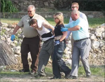  ?? The Sentinel-Record/Richard Rasmussen ?? IN CUSTODY: Garland County Sheriff’s Department Capt. Scotty Dodd, left, a LifeNet employee, third from right, Lt. Joel Ware and Under Sheriff Jason Lawrence, back, right, escort Robert Bailey from the scene of a shooting incident on Pinehill Road on Wednesday.