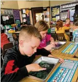  ??  ?? First-graders at John H. Morrison Elementary use sand trays to help with letter sounds. Teachers tried a multisenso­ry approach to reading.